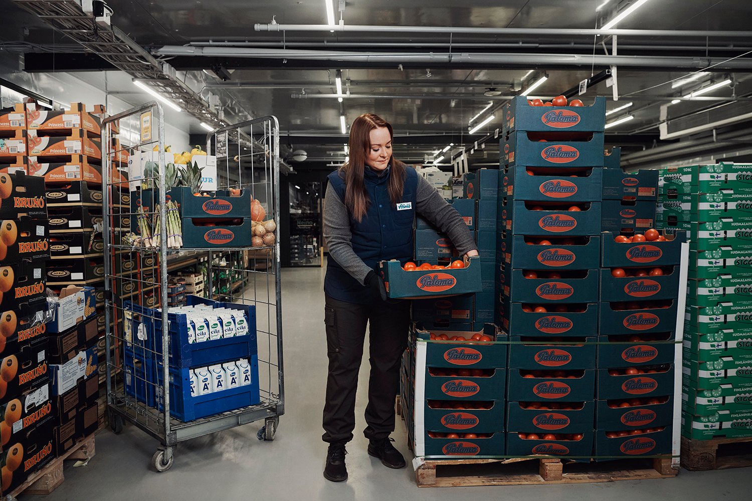 Työntekijä nostaa tomaattilaatikoita pikatukkujen hevi-osastolla